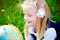 Portrait of pretty blond school girl discovering the globe on the grass outdoors