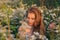 Portrait of pretty blond woman with closed eyes sitting in chamomile field