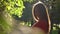 Portrait of pretty brunette girl in red dress in the park. Slow motion video, 120 fps