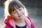 Portrait of a pretty child girl with resting relaxed expression outdoors