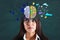 Portrait of pretty european businesswoman with creative colorful brain sketch on wall background. Brainstorm and hemispheres