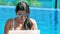 Portrait of pretty freelancer woman in sunglasses working at swimming pool using laptop