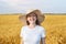 Portrait of pretty funny woman in hat on background of wheat field