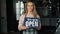 Portrait of pretty girl standing in cafe holding open sign welcoming customers