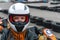 Portrait of a pretty girl wearing a white helmet close up, detail of Go-kart. karting track racing, copy space. serious look,