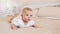 Portrait of pretty infant in white clothes on a bed at home