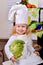 Portrait of a pretty little girl in cook clothes on kitchen