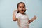 Portrait of pretty mulatto little girl dressed for sport. Pale blue background