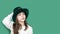 Portrait of pretty pensive emotional caucasian girl in fancy green leprechaun hat with gold buckle. concept promotion