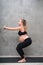 Portrait of pretty pregnant woman exercises on black mat in the gym