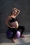 Portrait of pretty pregnant woman exercises with fitball in the gym