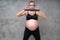 Portrait of pretty pregnant woman exercises with resistance band in the gym