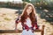 Portrait of pretty redhead cowgirl leaning on the ranch fence