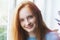 portrait of pretty smiling red haired young girl, sunny morning light