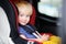 Portrait of pretty toddler boy sitting in car seat