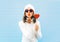 Portrait pretty woman blowing red lips sends air kiss holds lollipop heart wearing a heart shape sunglasses, knitted hat