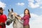 Portrait of pretty woman brushing her white horse