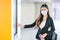 Portrait of pretty woman with mask stand in front of door of sky train on the platform during coronavirus pandemic in city