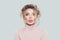 Portrait of pretty woman in pink turtleneck on white background. Model thinking, funny face