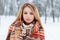 Portrait of a pretty young woman with brown eyes with beautiful makeup with long blond hair in a woolen vintage warm scarf