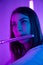 Portrait of a pretty young woman musician playing the flute. Female flutist plays wind instrument in a dark studio