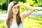 Portrait of pretty young woman in summer park looking in distance