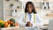 Portrait of professional african american dietitian sitting at workplace in weight loss clinic and smiling at camera