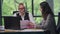 Portrait of professional Caucasian man talking with female assistant sitting in office analyzing paperwork. Smart male