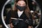 Portrait of professional female brow master in black robe with black gloves and black protective mask use brush and