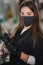 Portrait of professional female brow master in black robe with black gloves and black protective mask use brush and