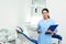 Portrait of professional female dentist with clipboard in clinic