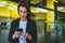 Portrait professional female finance lawyer standing near office in evening street communicates online by cellphone