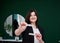 Portrait of professional hairdresser in beauty salon. Young female hair stylist holding work instruments - scissors and comb. Work