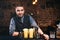 Portrait of professional handsome barman smiling at camera, preparing cocktails and serving fresh drinks