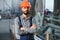 Portrait of Professional Heavy Industry Engineer Worker Wearing Safety Uniform, Hard Hat Smiling. In the Background