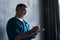 Portrait of professional mature surgeon looking at camera while standing against the grey background.