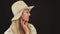 portrait profile of a young blonde woman with a hat thinking and looking down black background closeup studio shot copy