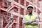 Portrait of proud black man engineer, construction site and mockup with scaffolding in city, planning and safety. Smile