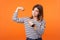 Portrait of proud confident woman with brown hair in long sleeve striped shirt. indoor studio shot isolated on orange background