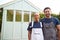 Portrait Of Proud Couple Standing In Front Of Completed Outdoor Summerhouse In Garden