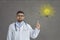 Portrait of proud doctor pointing at light bulb as symbol of innovative ideas and solutions