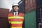 Portrait of proud engineer in protective workwear standing in a shipping yard