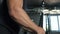 Portrait of a pumped athlete`s hands shaking his biceps in the gym