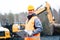 Portrait of a quarry worker standing in front of excavator