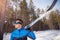 Portrait of racer male skier with cross country skis on background of winter forest
