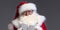 Portrait of real Santa Claus, looking at the camera, posing on gray studio background. Christmas is coming!  Xmas time