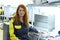 Portrait of red-haired woman factory worker sitting near production Assembly line at the plant for production of