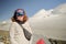 Portrait of a red-haired woman in a ski mask. Tourist climber on the background of Mount Kazbek