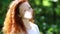 Portrait of a red-haired  woman with a sunny spot on her face