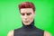 Portrait of redhead serious male plastic mannequin in dark turtleneck isolated on green background, close up.